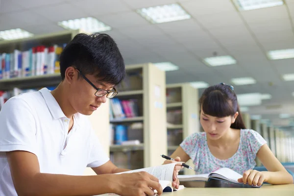 Jovens estudantes universitários estudam juntos na biblioteca — Fotografia de Stock
