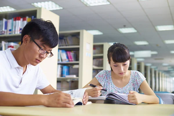 Giovani studenti universitari studiano insieme in biblioteca — Foto Stock
