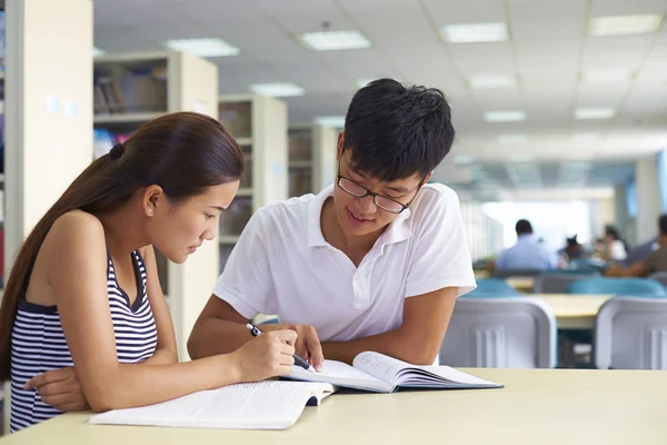 Giovani studenti universitari studiano insieme in biblioteca — Foto Stock