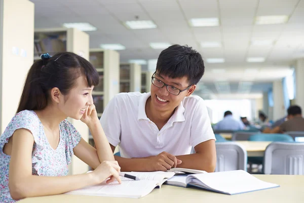 Jovens estudantes universitários estudam juntos na biblioteca — Fotografia de Stock