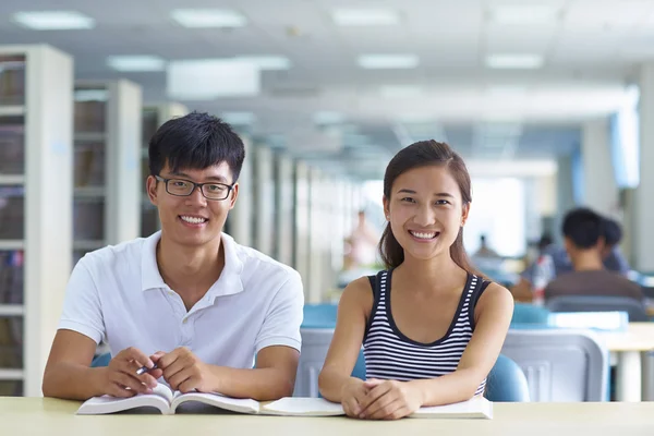 Jonge studenten studeren samen in de bibliotheek — Stockfoto
