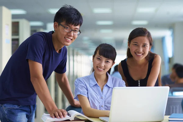 Jonge studenten studeren samen in de bibliotheek — Stockfoto