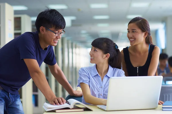 Unga studenter studera tillsammans i biblioteket — Stockfoto