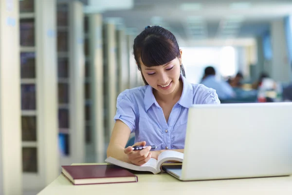 Una studentessa studia in biblioteca — Foto Stock