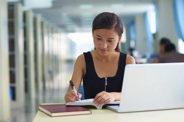 Una estudiante universitaria en la biblioteca —  Fotos de Stock