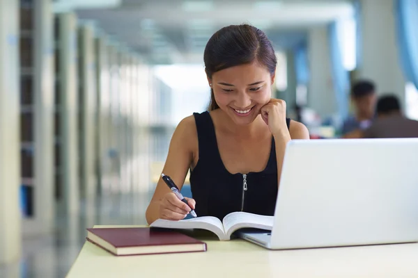 Una estudiante universitaria en la biblioteca —  Fotos de Stock