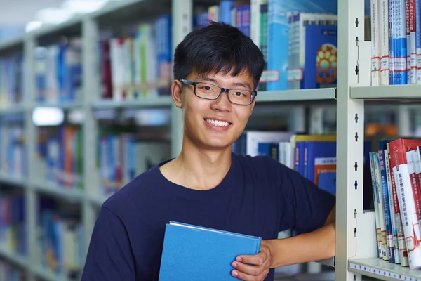 Genç erkek üniversite öğrencisi librar kamera gülümseme bakarak