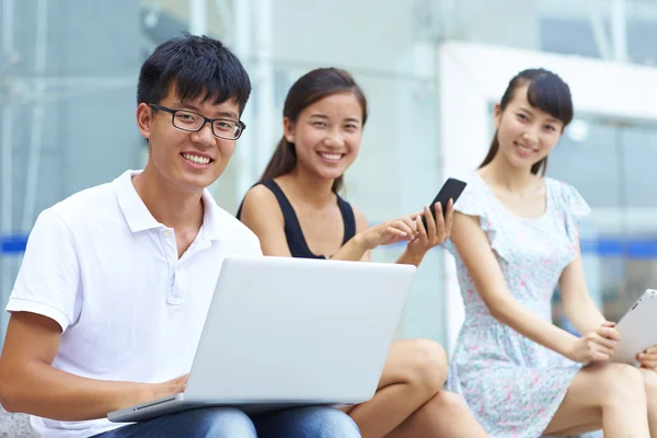 Young asian college student using laptop or tablet together outd — Stock Photo, Image