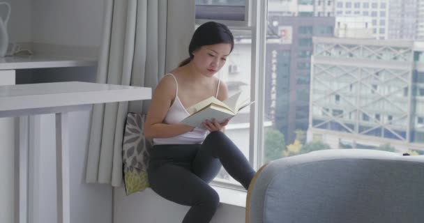 Asian young happy woman relaxing holding reading book — Stock Video