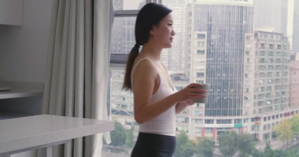 Aziatische vrouw kijken uit het raam genieten van het uitzicht — Stockvideo