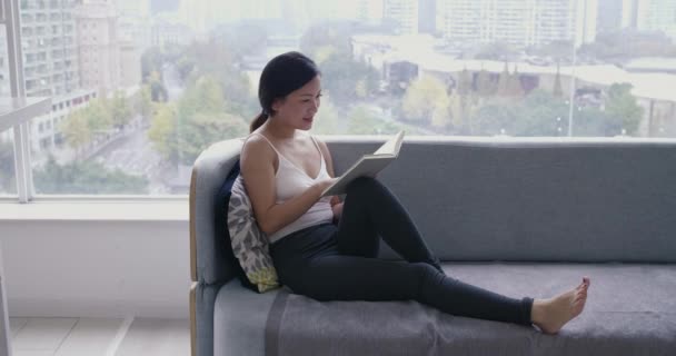 Молодая азиатка читает книги в тренере дома — стоковое видео