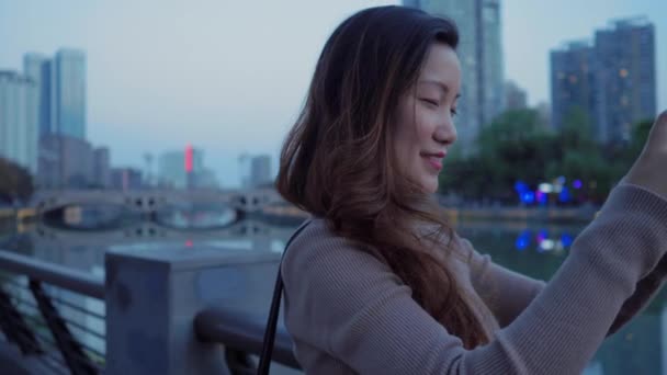 Cabelo longo mulher asiática usando telefone tirar foto da cidade — Vídeo de Stock