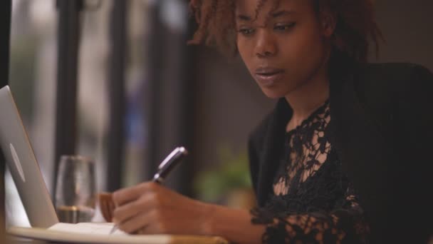 若いアフリカ人フリーランスの作家がカフェで書く — ストック動画