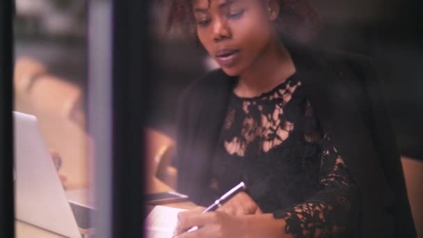 Jonge Afrikaanse freelance schrijver schrijven in cafe — Stockvideo