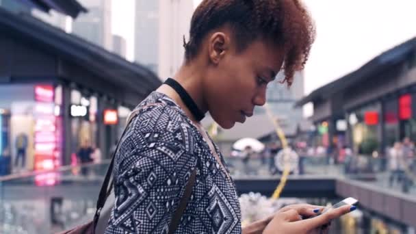Mujer joven usando teléfono móvil en la calle urbana — Vídeos de Stock