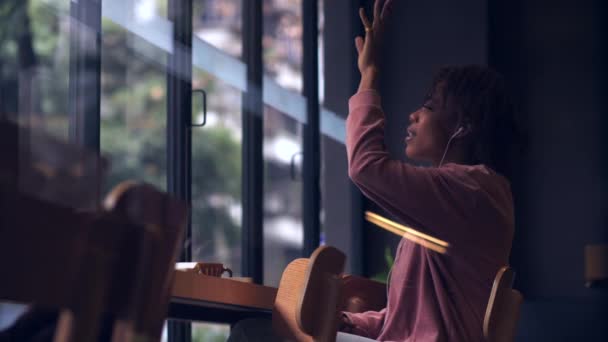 Hübsche afrikanische Mädchen genießen Musik auf dem Handy im Café Zeitlupe — Stockvideo