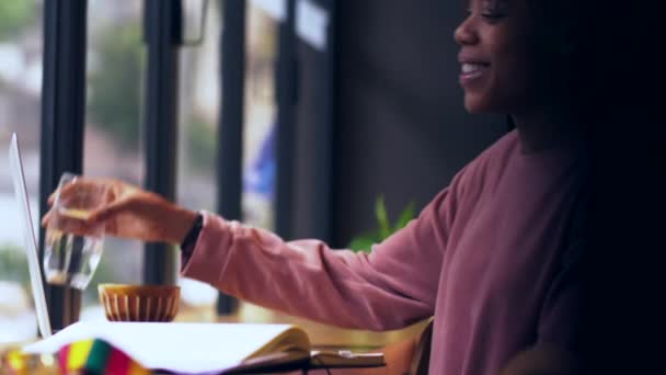 Jeune étudiant africain étudiant utilisant un ordinateur portable dans un café — Video