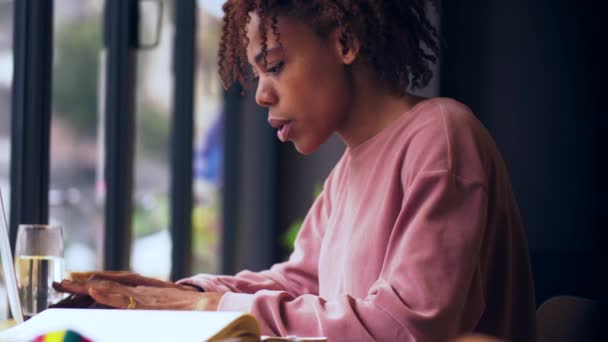 Primo piano di giovane donna africana impegnata a lavorare sul computer portatile al coperto — Video Stock