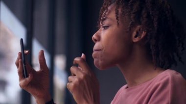 Cep telefonuna ruj süren genç bir kadın.