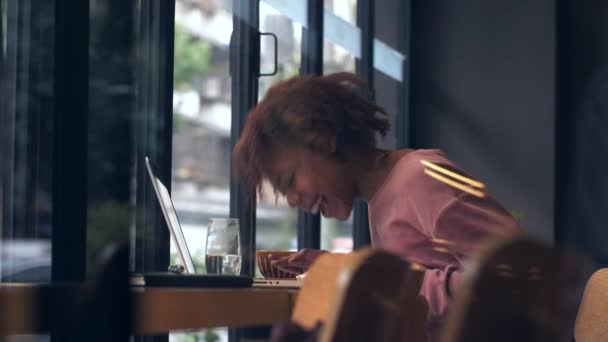 Elég boldog afrikai fiatal lány használja laptop kávézóban — Stock videók