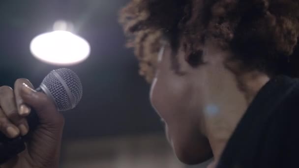 Κοντινό πλάνο του χαρούμενου νεαρού Αφρικανού τραγουδιστή που τραγουδάει στη σκηνή — Αρχείο Βίντεο