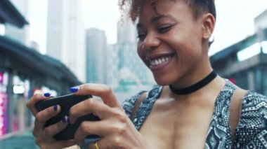 Çin caddesinde cep telefonu kullanarak gezen Afrikalı genç bir kadın.
