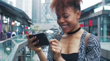 Çin caddesinde cep telefonu kullanarak gezen Afrikalı genç bir kadın.