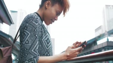 Çin caddesinde cep telefonu kullanarak gezen Afrikalı genç bir kadın.