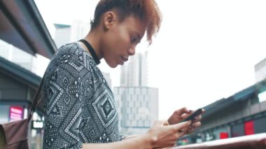  Çin caddesinde cep telefonu kullanarak gezen Afrikalı genç bir kadın.