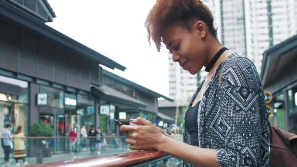 Çin caddesinde cep telefonu kullanarak gezen Afrikalı genç bir kadın. — Stok video