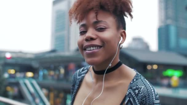 Glückliche schwarze junge Frau genießt Musik auf der Straße — Stockvideo