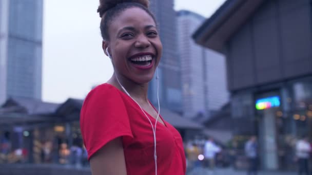 Mutlu siyahi genç kadın sokaklarda müzik dinlemekten hoşlanıyor. — Stok video