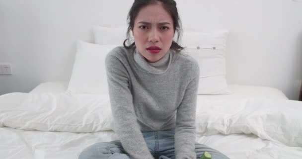 Naštvaná dívka jíst okurky sedí v posteli — Stock video