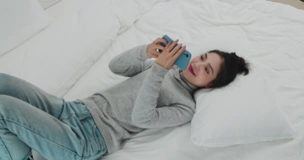 Jong meisje video chatten in bed — Stockvideo