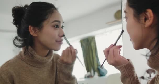 Mignonne asiatique fille appliquant maquillage en face du miroir — Video