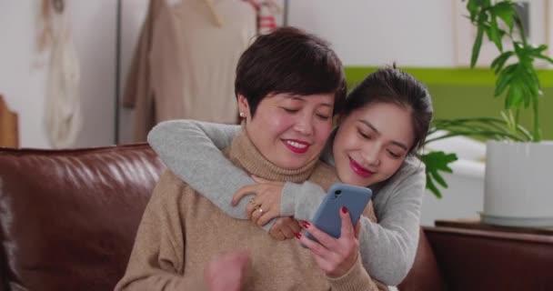 Mère et fille adulte utilisant le téléphone à la maison — Video