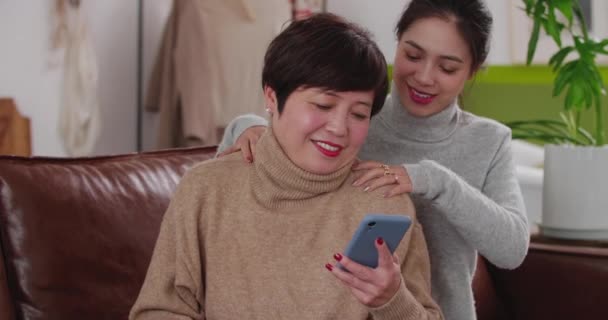 Madre e figlia adulta utilizzando il telefono a casa — Video Stock