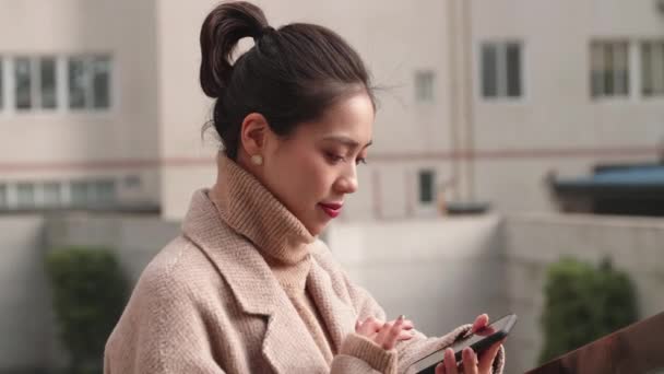 Joven mujer de negocios asiática usando teléfono móvil — Vídeo de stock