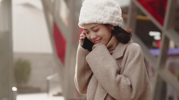 幸せなアジアの女の子は電話で話している — ストック動画