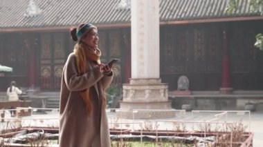 Genç Asyalı kadın tapınakta yürümekten zevk alıyor.