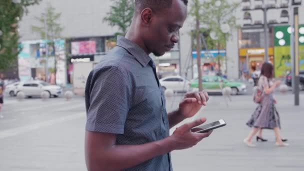 Negro hombre jugando teléfono móvil — Vídeo de stock