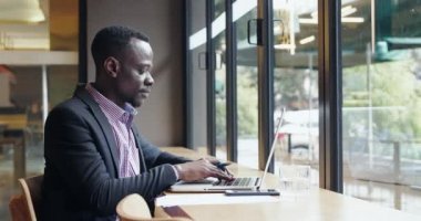 Dizüstü bilgisayarda yazan mutlu Afrikalı genç adam