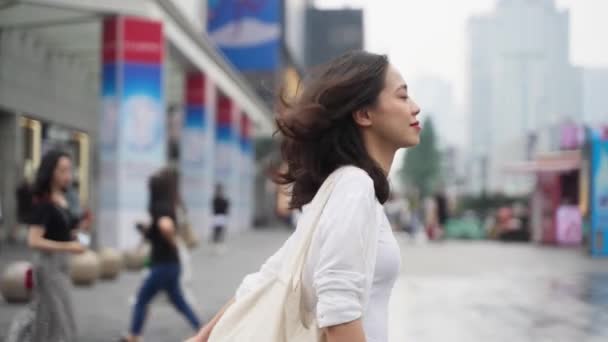成都都市部の街を歩くかなり幸せな若いアジアの女性4Kスローモーション側のビュー素敵な女性は 日通りのライフスタイルをお楽しみください — ストック動画