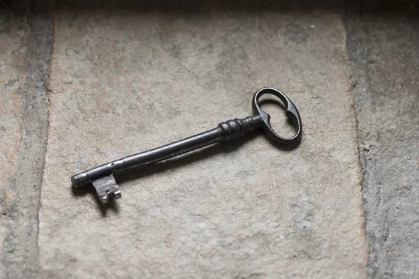 Old iron key on stone