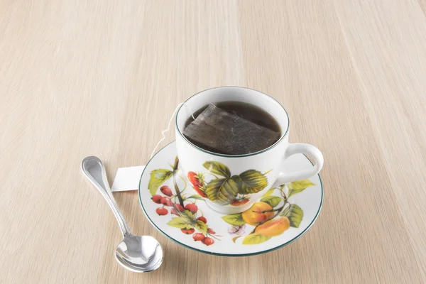 Tasse Tee und Teelöffel auf Holztisch — Stockfoto