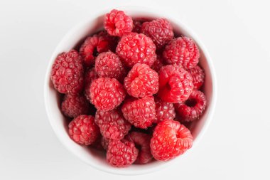 Beyaz arka planda izole edilmiş bir kasede taze ahududu.