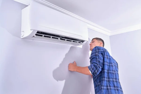 Een Man Inspecteert Airconditioner Thuis Controleert Het Werkt — Stockfoto