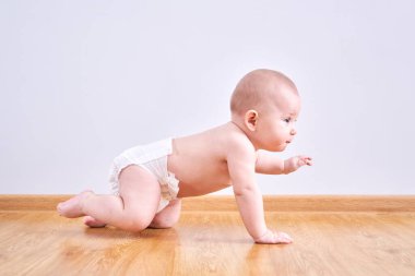 Bezli küçük çocuk evde yerde sürünmeyi öğreniyor.