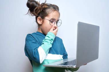 Şok olmuş, ağzı açık, gözleri şişmiş bir çocuk bilgisayar ekranına bakıyor. İnternet porno sansür konsepti, yetişkin içeriği 18+