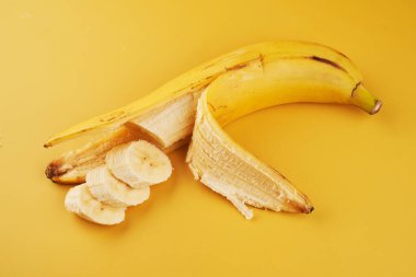 Sarı arka planda dilimlenmiş muz. Yakın plan. Sağlıklı tatlı malzemesi.